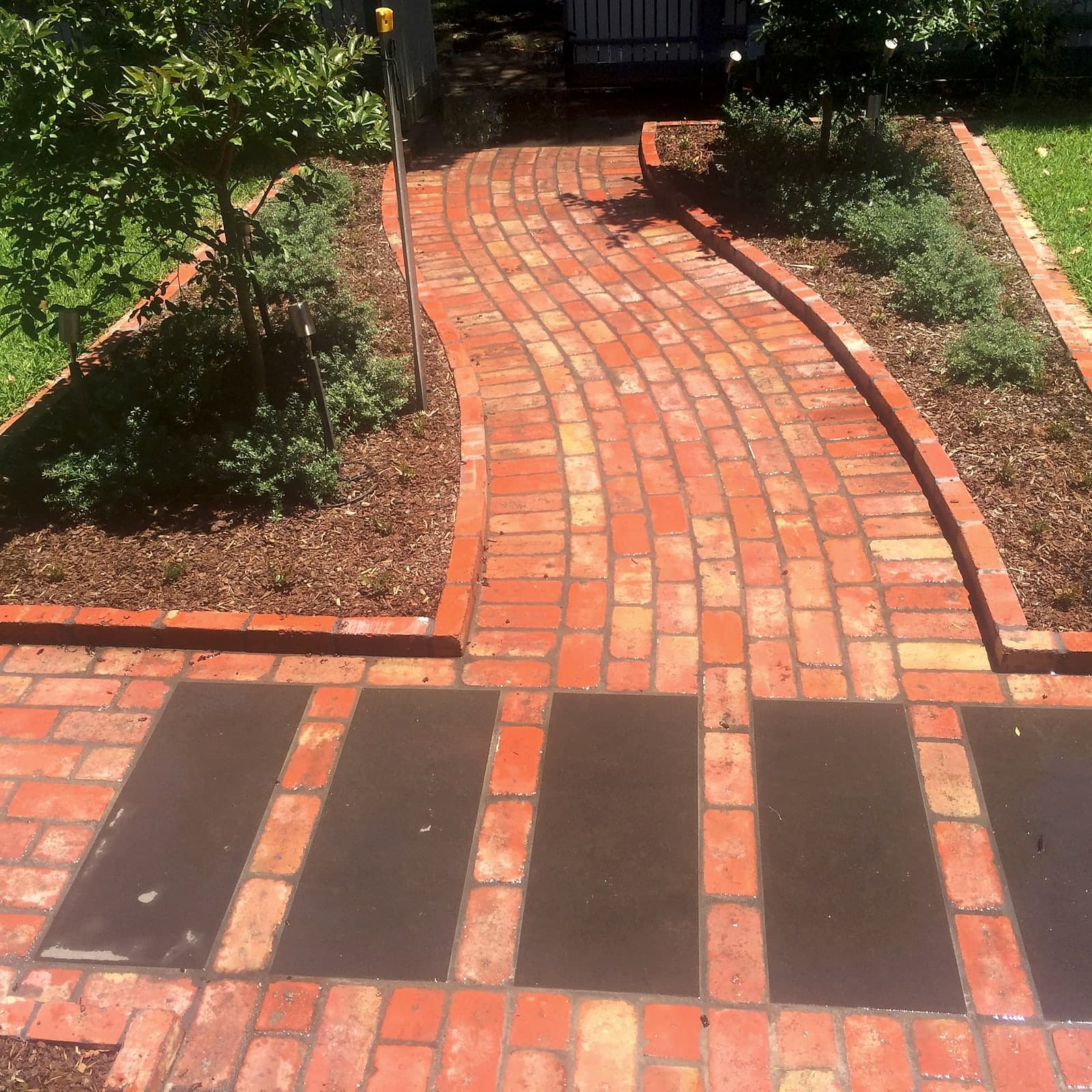 Brick path with charcoal steppers by Cam Wells Paving