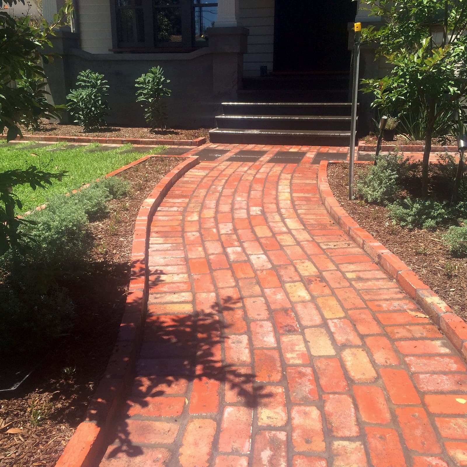 Curved brick entry path by Cam Wells Paving